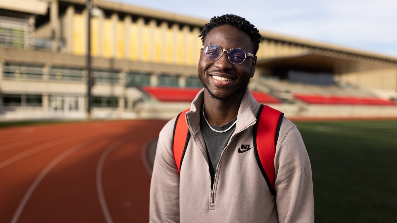 Emmanuel Adegboyega, récipiendaire d’une bourse d’études Ted Rogers, sur une piste de course à l’extérieur.