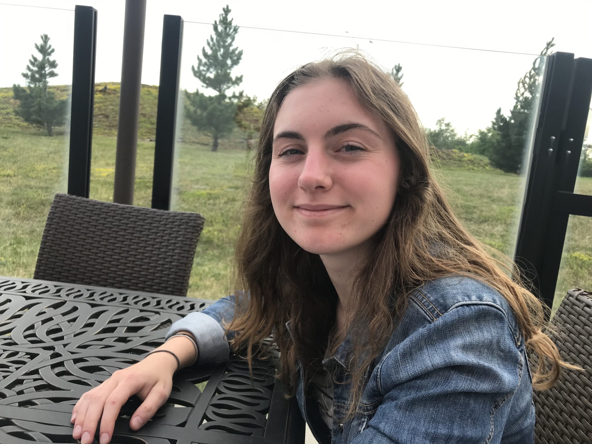 Abby, récipiendaire d’une Bourse d’études Ted Rogers, assise à une table à l’extérieur.